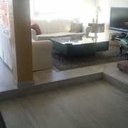 Colocación de parquet laminado a dos niveles, con pieza especial de peldaño fabricada con el mismo material.