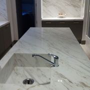 Isla en marmol Volakas diagonal con lavabo integrado