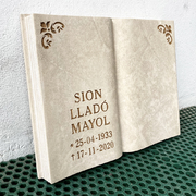 Libro de piedra natural con inscripción y motivos.