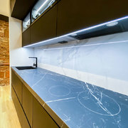 Cocina negra, placa integrada Cooking Rak y frente statuario