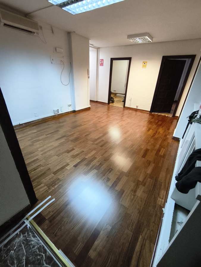 Instalación de parquet nuevo color sapeli en sala de oficina