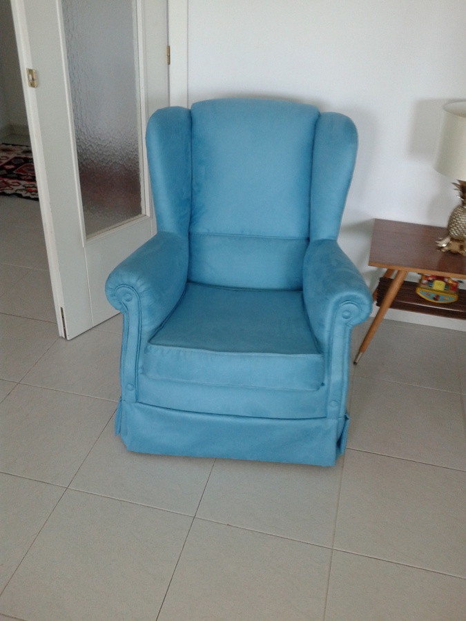 Sillón orejero tapizado en terciopelo turquesa