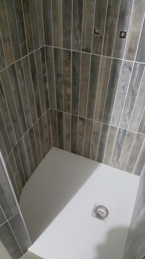Interior de ducha con muro en curva.
