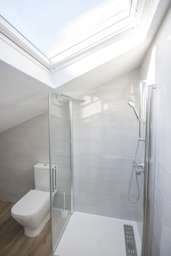 Baño con ventana en techo en buhardilla