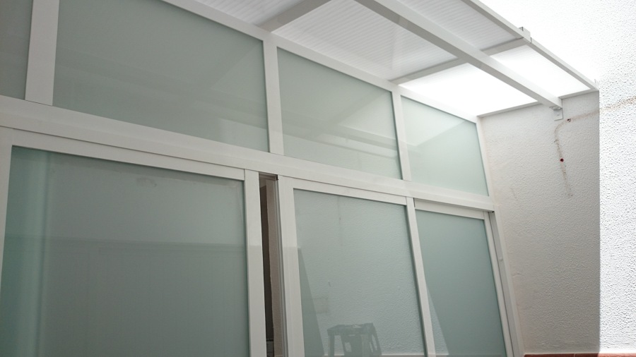 Cerramiento de terraza cn puerta corredera 4 hojas centro tope y techo de macrolom