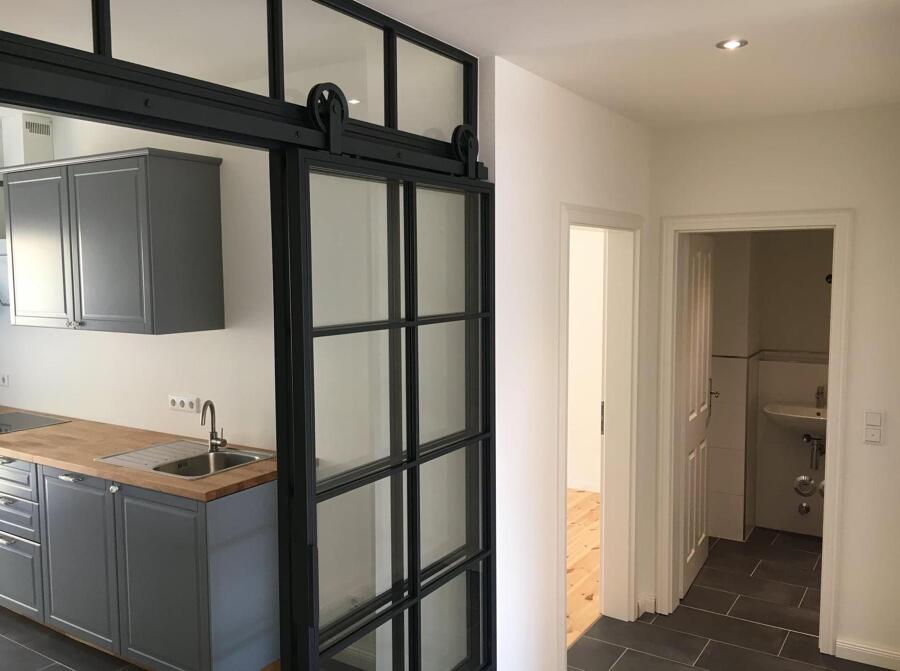 magen de cocina con puerta corredera hacia salón luminoso