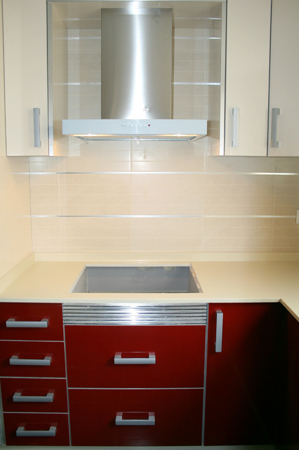 DETALLE FRENTE COCINA ZONA COCCION CON MOBILIARIO LACADO EN ROJO