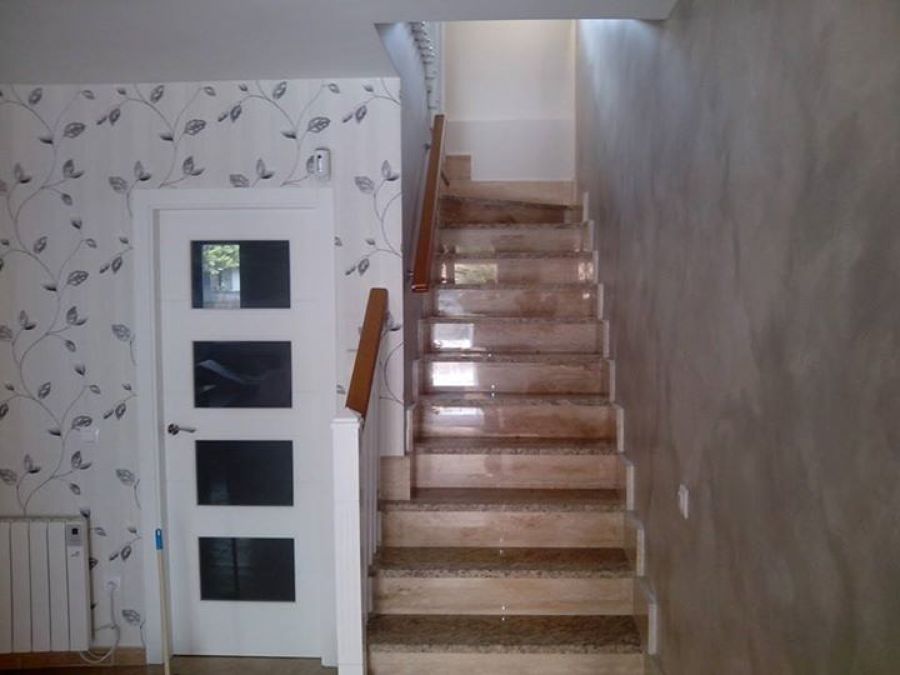 En la parte izquierda se ha colocado un papel pintado y en la subida de la escalera y el salon se a aplicado una patina gris con efecto metalizado