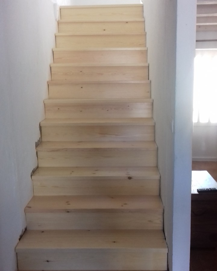 Escalera en madera de pino como cae barnizada al natural .
