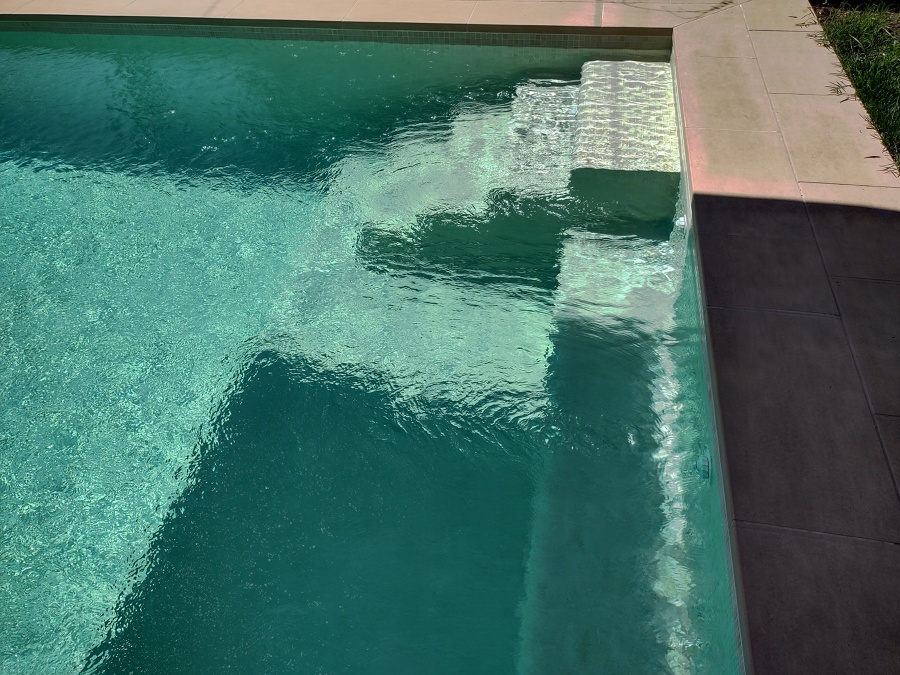 Piscina con entorno beige y revestimiento beige