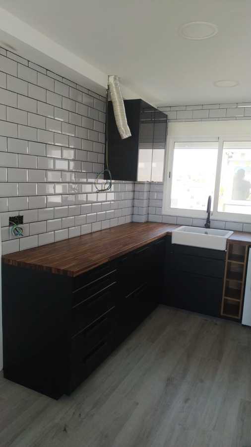 Cocina rústica con tonos negros, maderas y blancos para un ambiente cálido y acogedor
