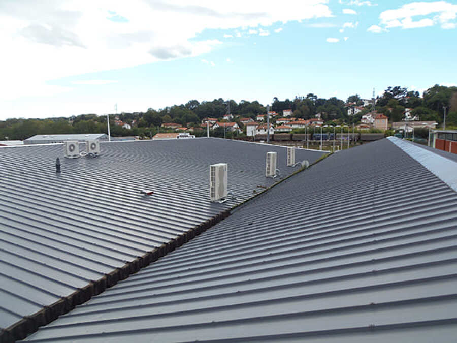 Cubierta de panel sándwich con remates de ventilación.