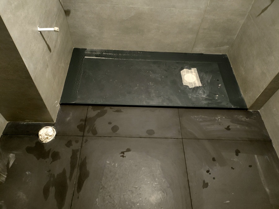Plato de ducha negro con suelo marrón haciendo juego con la baldosa de la pared perfecto