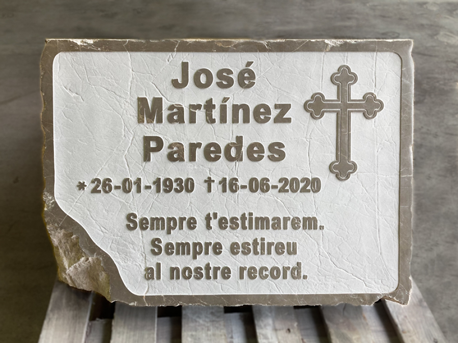 Lápida grabada en relive con dedicatoria y motivo.