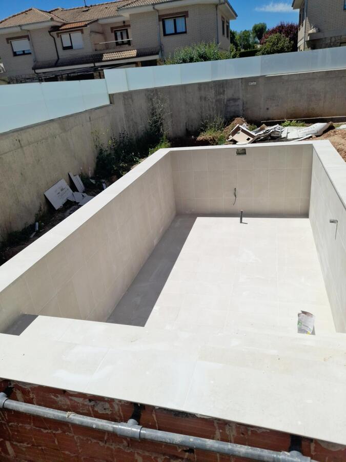 Revestimiento integral y coronación de piscina en gres porcelánico.