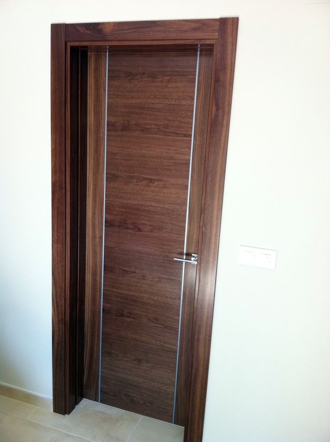 Puerta en nogal con grecas en aluminio