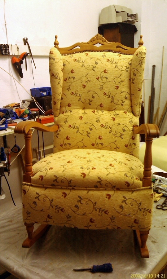 Sillón orejero con brazos de madera y balancín