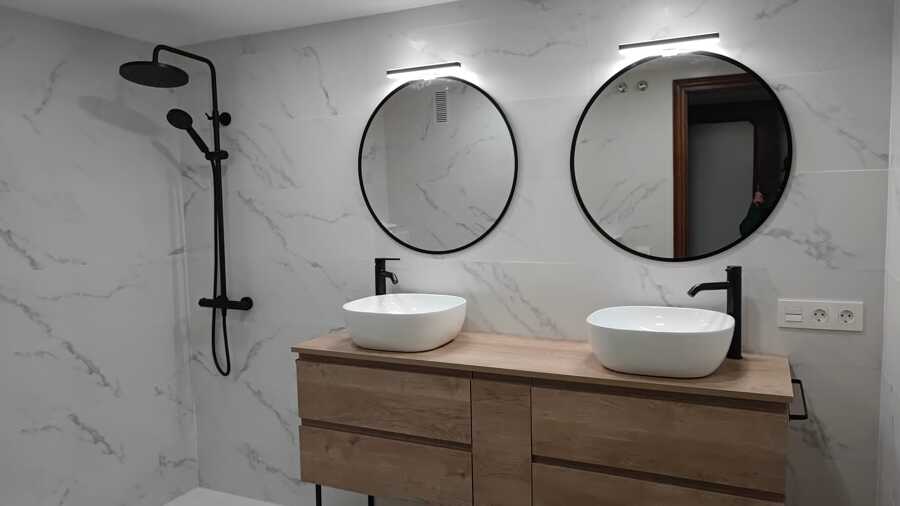 Baño principal con doble lavabo: mármol blanco, madera y detalles en negro mate