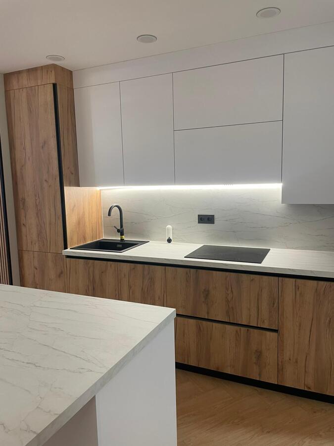 Cocina en madera y blanco con encimera y frente porcelánicos