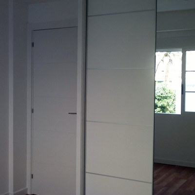 armario a medida.techos y paredes de pladur,puerta de paso blanca con rayas.tarima flotante quick step