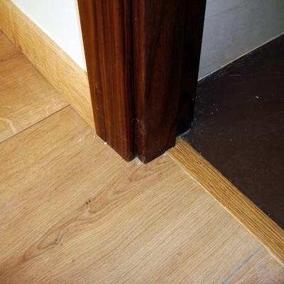 Detalle de tarima, marco de puerta y solado cerámico