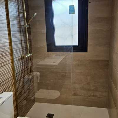 Reforma de baño con mampara a techo dorada