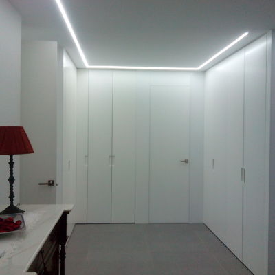 Iluminación de led y armarios y panelado lacados en blanco.