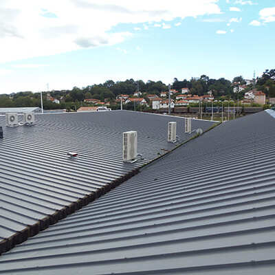 Cubierta de panel sándwich con remates de ventilación.