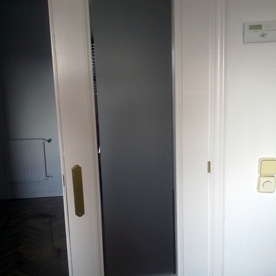 Puerta restaurada con esmalte en blanco y vidrio mateado con bisel