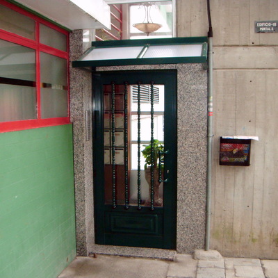 puertta de acceso con tejadillo en aluminio verde