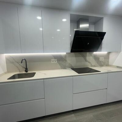 Cocina blanca con encimera y frente porcelánicos efecto mármol