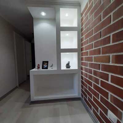 Reforma moderna de salón con pared decorativa y iluminación LED