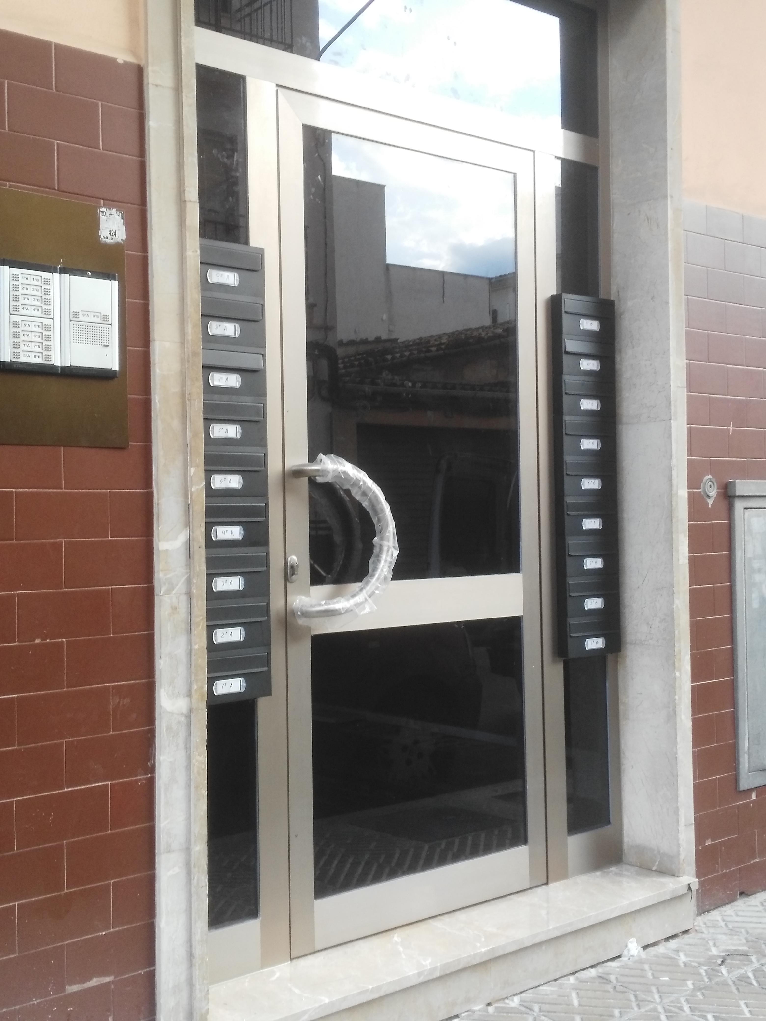 Puerta de entrada de comunidad con buzones