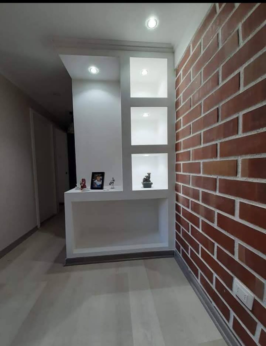 Reforma moderna de salón con pared decorativa y iluminación LED