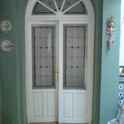 Puerta doble vidriera con medio punto.