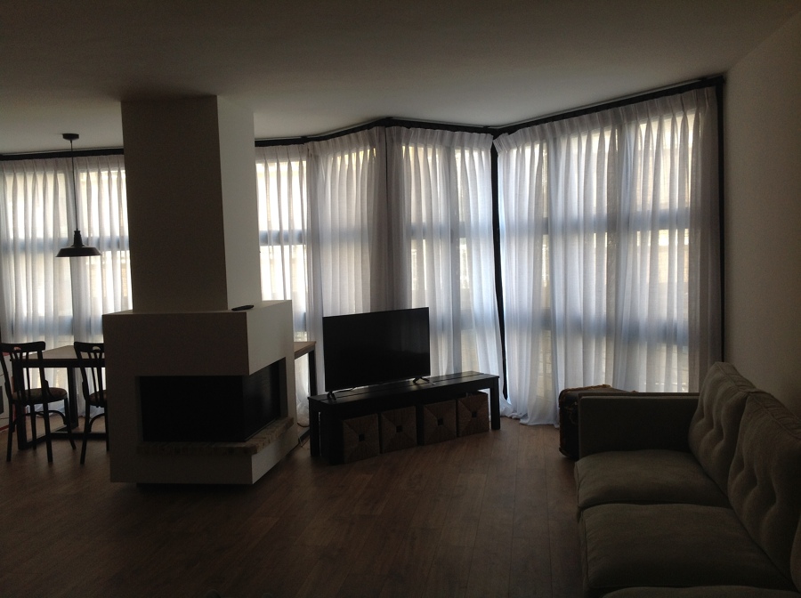 Cortinas y sofá con scheslongue abotonado.