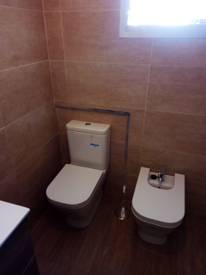 enmarcado con perfil de acero inox. para inodoro.