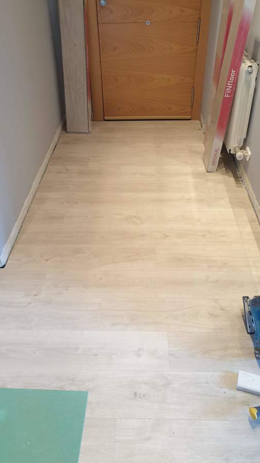 Instalación de suelo laminado sobre aislamiento de fibra de madera y manta antisonido.