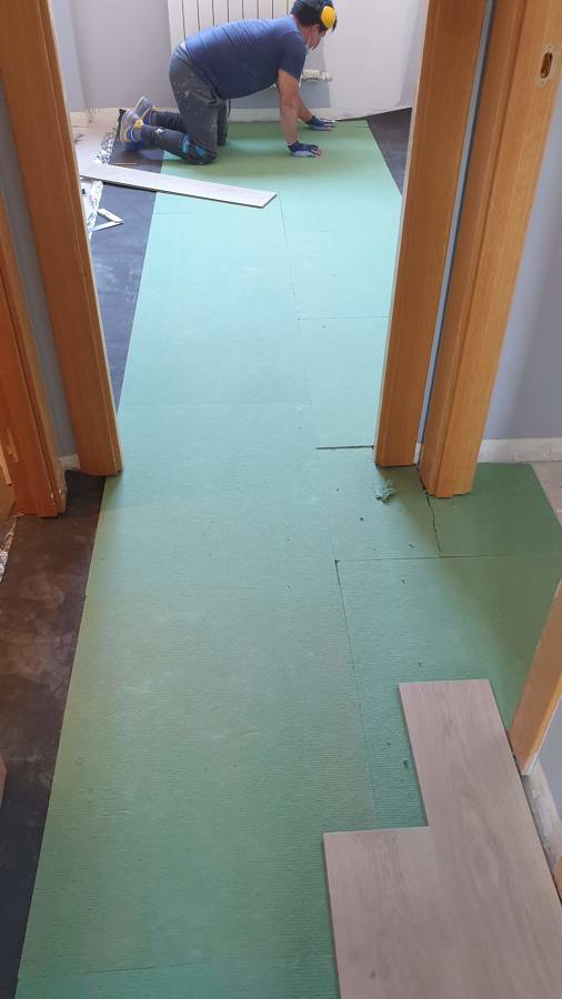 Instalación de suelo laminado sobre aislamiento de fibra de madera y manta antisonido.