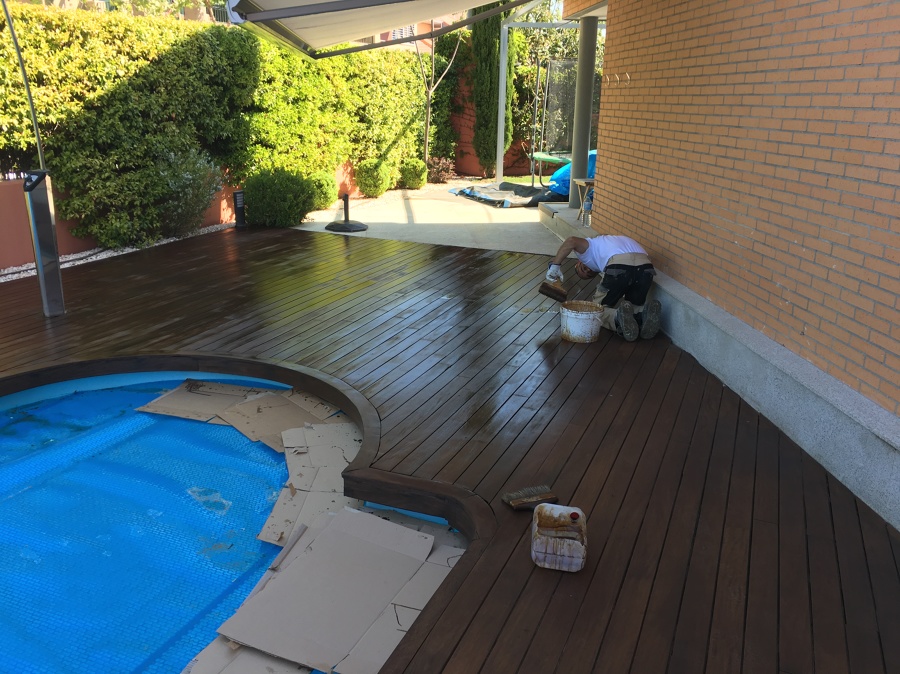 Mano de protector de lasur con pigmentos protectores de tarima