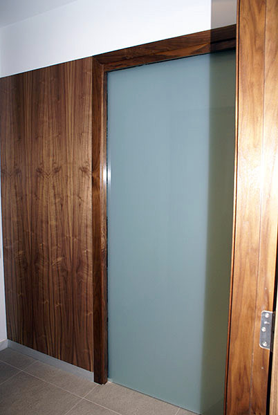 puerta corredera cristal panelado en madera de nogal