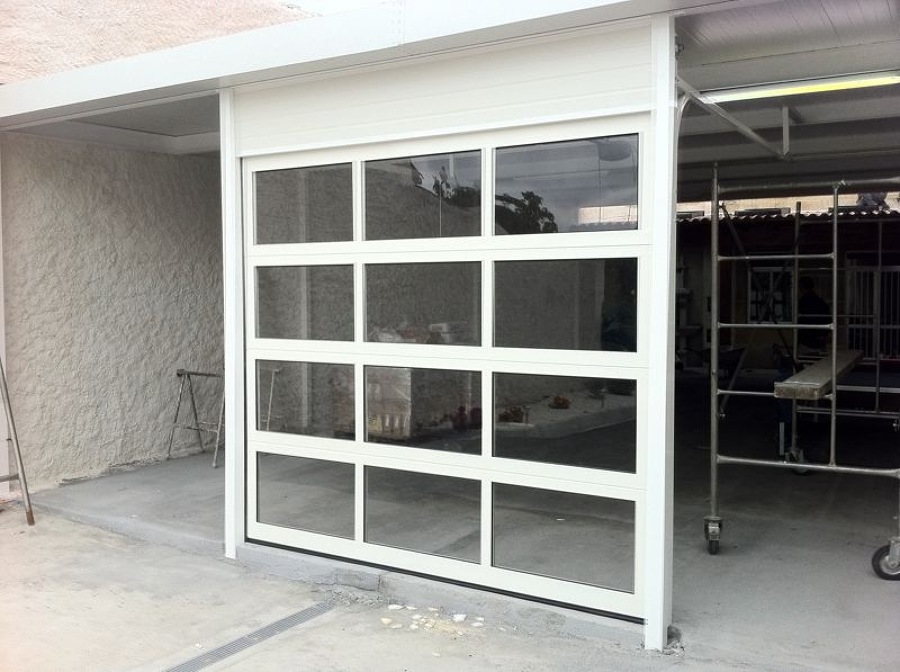 Puerta seccional blanca con ventanas.