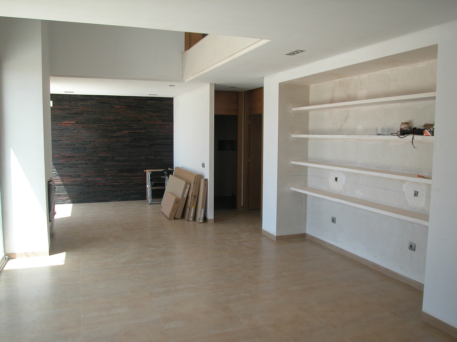 Salón con estanterías de obra.