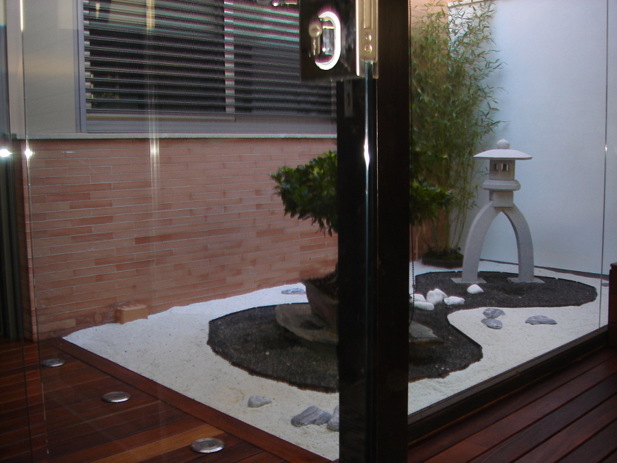 Vista del jardin japones, con bonsai,juncos y lamapara japonesa
