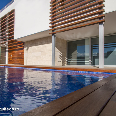 Detalle de la tarima de madera que bordea la piscina y las lamas que conforman la celosía