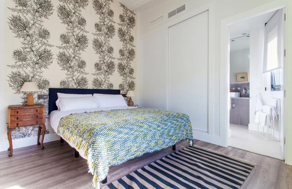Dormitorio con papel pintado con motivos florales y baño en suite