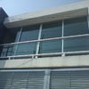 Balcón con estructura de metal y cristal transparente.