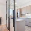 cocina abierta al salón con mampara de hierro y cristal