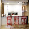 Cocina con barra negra y taburetes rojos