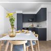 Cocina moderna abierta al salón con electrodomésticos integrados.